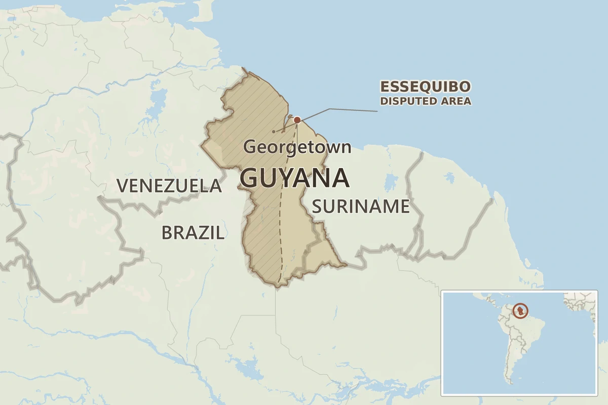 Map showing Guyana on the northern coast of South America, with Venezuela, Brazil, Suriname, the Atlantic Ocean, Georgetown, a South America locator, and the Essequibo disputed area marked neutrally.